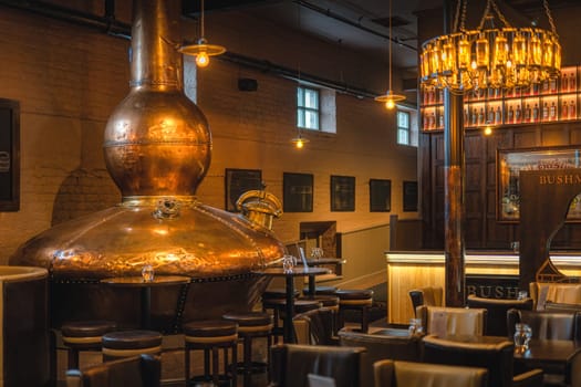 Bushmills, Northern Ireland, Aug 2019 Large, copper fermentation vat in Bushmills whiskey bar as decoration, distillery visitor centre and shop