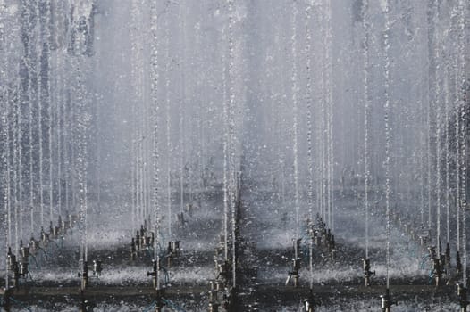 High fountain spraying water in the park. fountain spray system close up