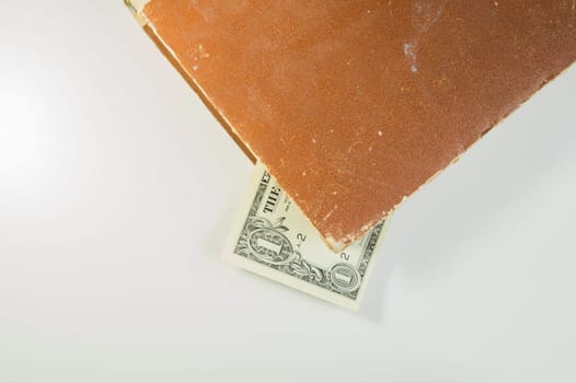 Money in a book. dollar bill used as a bookmark in the book on a white background. copy space