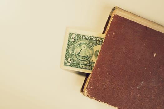 Money in a book. dollar bill used as a bookmark in the book on a white background. copy space