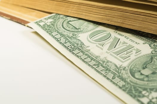 Money in a book. dollar bill used as a bookmark in the book on a white background. copy space