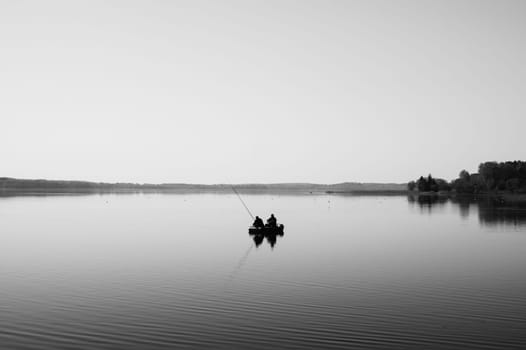 Fishermen catching fish. silhouette of fishers on a fishing boat. calm background