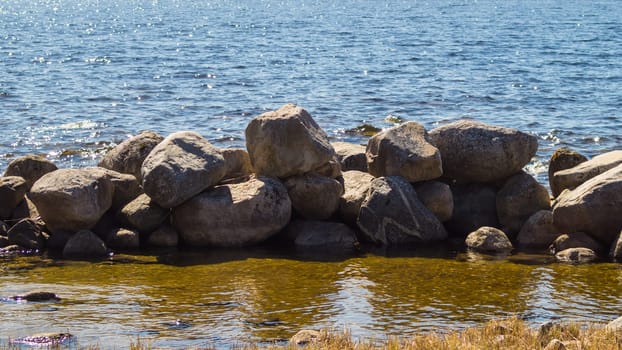 Dam from stones. dyke made from natural materials. pile of rocks in the water