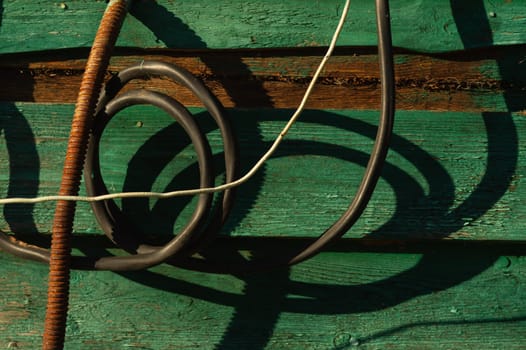 Old hoses hanging on the green wall of wooden house