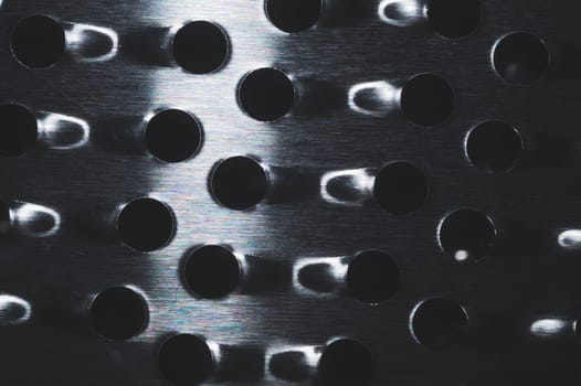Grater with holes close up background. metal grid with round cell