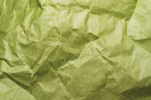 Crumpled green paper close up. creased kraft paper material