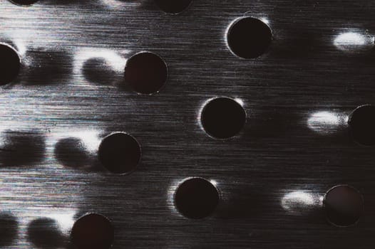 Grater with holes close up background. metal grid with round cell