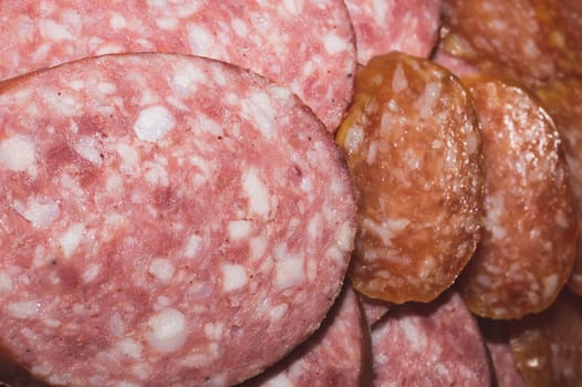Salami background. many sliced pieces of sausage