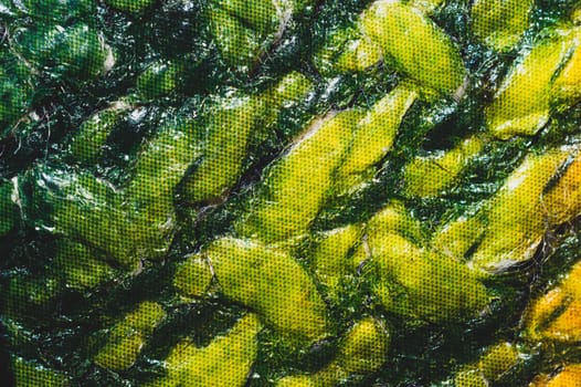 Green material close up background. creased cloth abstract texture
