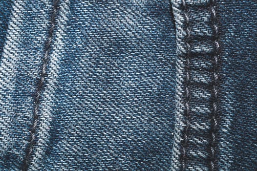 Jeans background with seams. denim texture close up. fabric backdrop with stitches