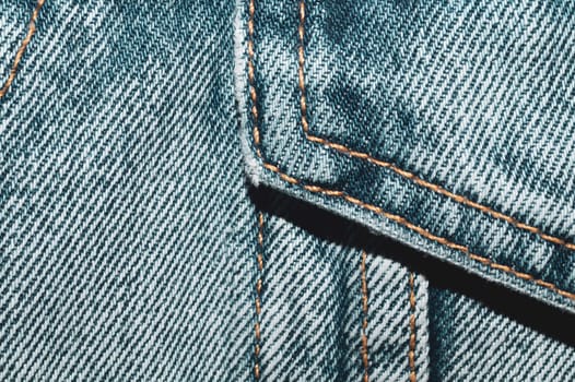 Jeans background with seams. denim texture close up. fabric backdrop with stitches