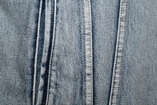 Jeans background with seams. denim texture close up. fabric backdrop with stitches