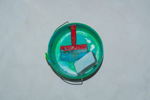 Empty paint bucket with used brush. process of renovation