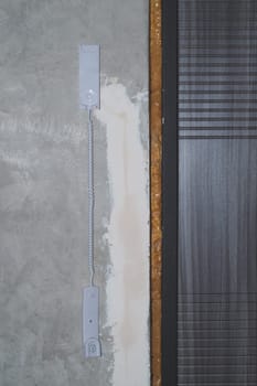 Entrance door and intercom phone receiver on the wall. handset hanging on the gray concrete background close up