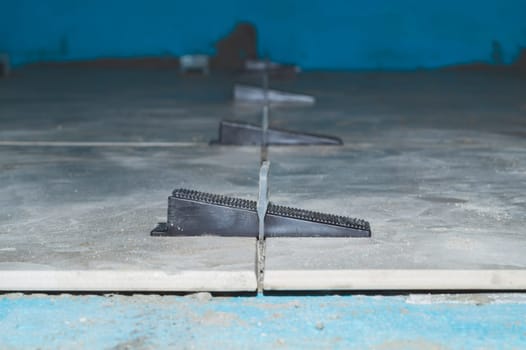 Tile leveling system. plastic clips for laying granite tiles on the floor close up