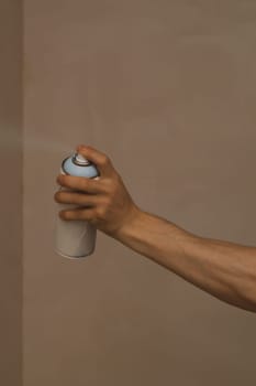 Spray can in the hand. spraying paint on the wall. painting process