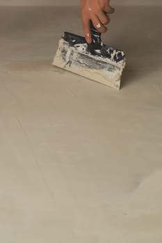 Hand holds construction spatula with putty. trowel with spackling. process of renovation