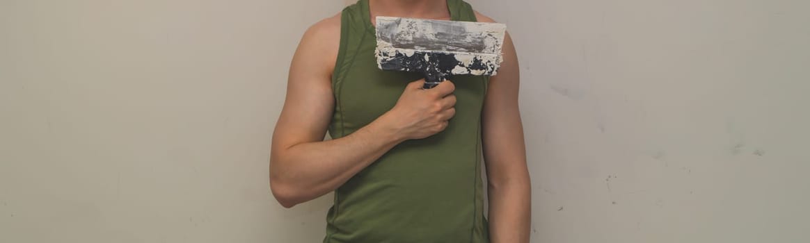 Man holds construction spatula with putty. trowel with spackling. process of renovation