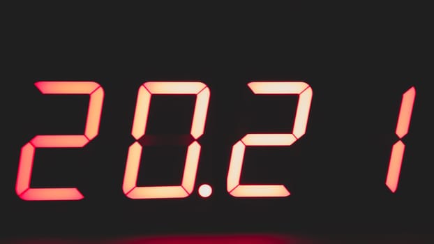 Digital clock with red led light illumination numbers 2021 in the dark. electronic timer
