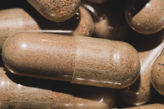 Brown capsule pills macro background. herbal medicine
