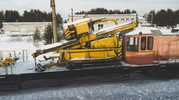 Construction train with yellow machine with locomotive. winter weather