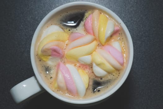 Twisted marshmallows in a cup of coffee. drink with chewy candy