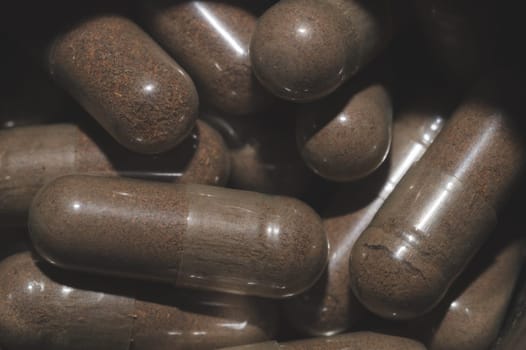 Brown capsule pills macro background. herbal medicine