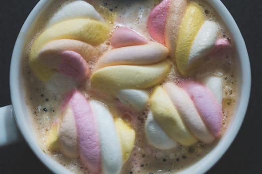 Twisted marshmallows in a cup of coffee. drink with chewy candy