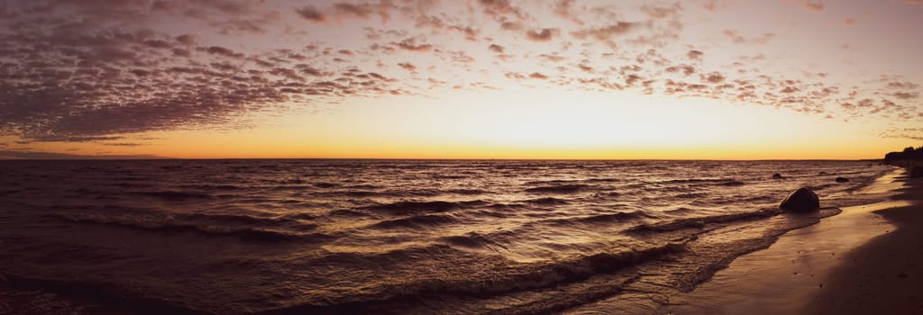 Golden sunset over the sea with sand beach. sky with clouds at the evening. panoramic view
