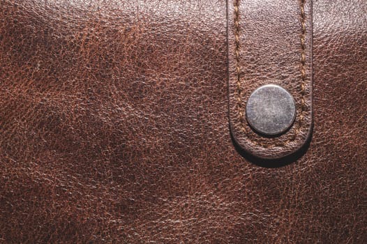 Brown leather texture background. rough material close up. metal button