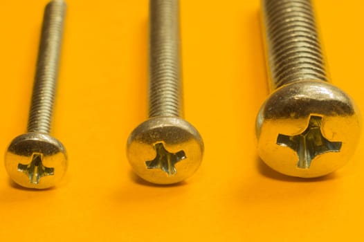 Steel screw on a yellow background. working tools