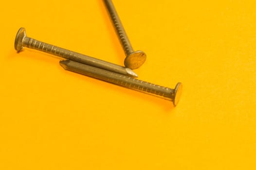 Steel screw on a yellow background. working tools