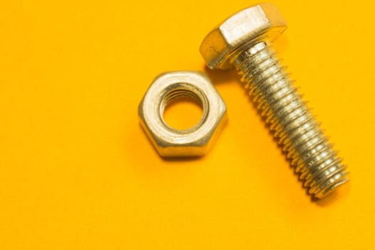 Steel screw on a yellow background. working tools