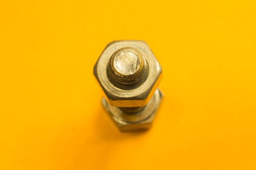 Steel screw on a yellow background. working tools