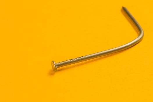Steel screw on a yellow background. working tools