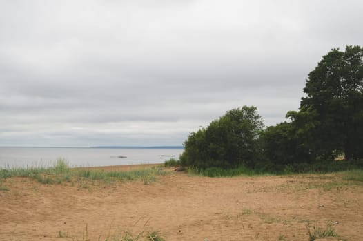 Sand beach in the bay under cloudy sky