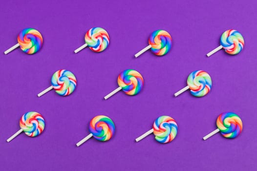 Lollipops are arranged symmetrically on a colored background. colorful candies. pattern of sweets