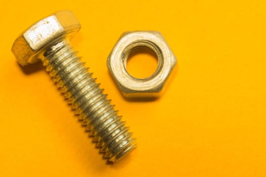 Steel screw on a yellow background. working tools