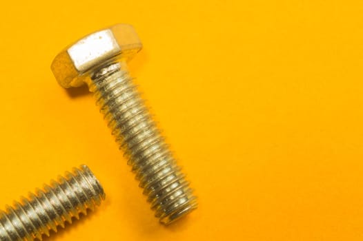 Steel screw on a yellow background. working tools