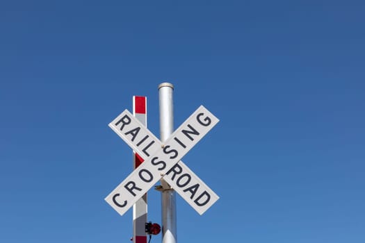 railroad crossing sign under clear blue sky