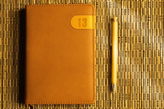 Diary and pen on a wooden bamboo background. notebook and pen top view. copy space