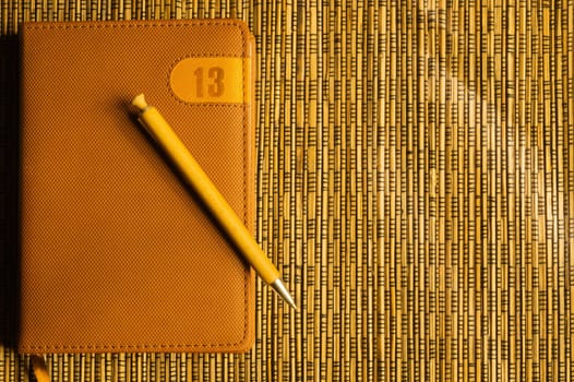 Diary and pen on a wooden bamboo background. notebook and pen top view. copy space