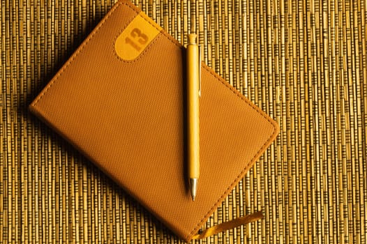 Diary and pen on a wooden bamboo background. notebook and pen top view. copy space