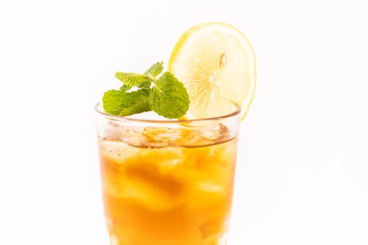 Refreshing ice lemon tea with mint leaves on a white background