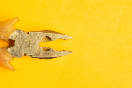 Pliers with orange handles on yellow background. work tool. copy space