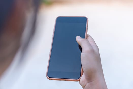 Hand women with smart phone black screen blurred background