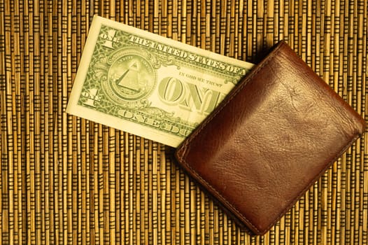 One dollar in a wallet on a wooden bamboo background. money on the table. finance background