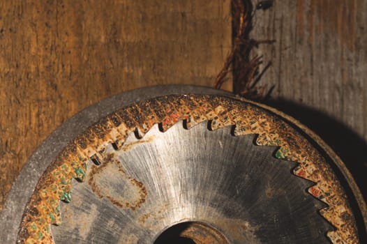 Metal circular saw blade on a wooden background. top view. work tool. carpentry instrument