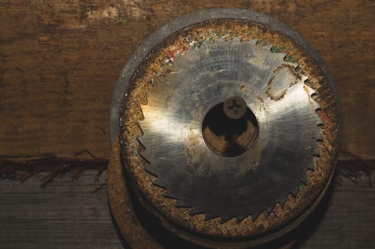 Metal circular saw blade on a wooden background. top view. work tool. carpentry instrument