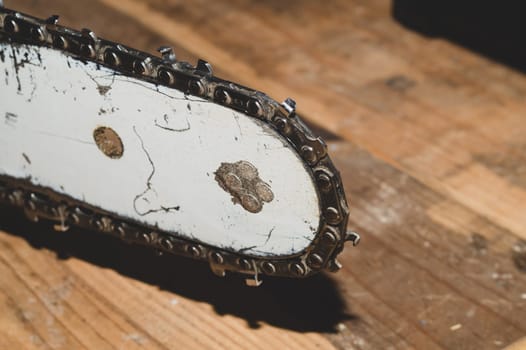 Chainsaw bar and cutting chain close up. blade of a chainsaw on a wooden background